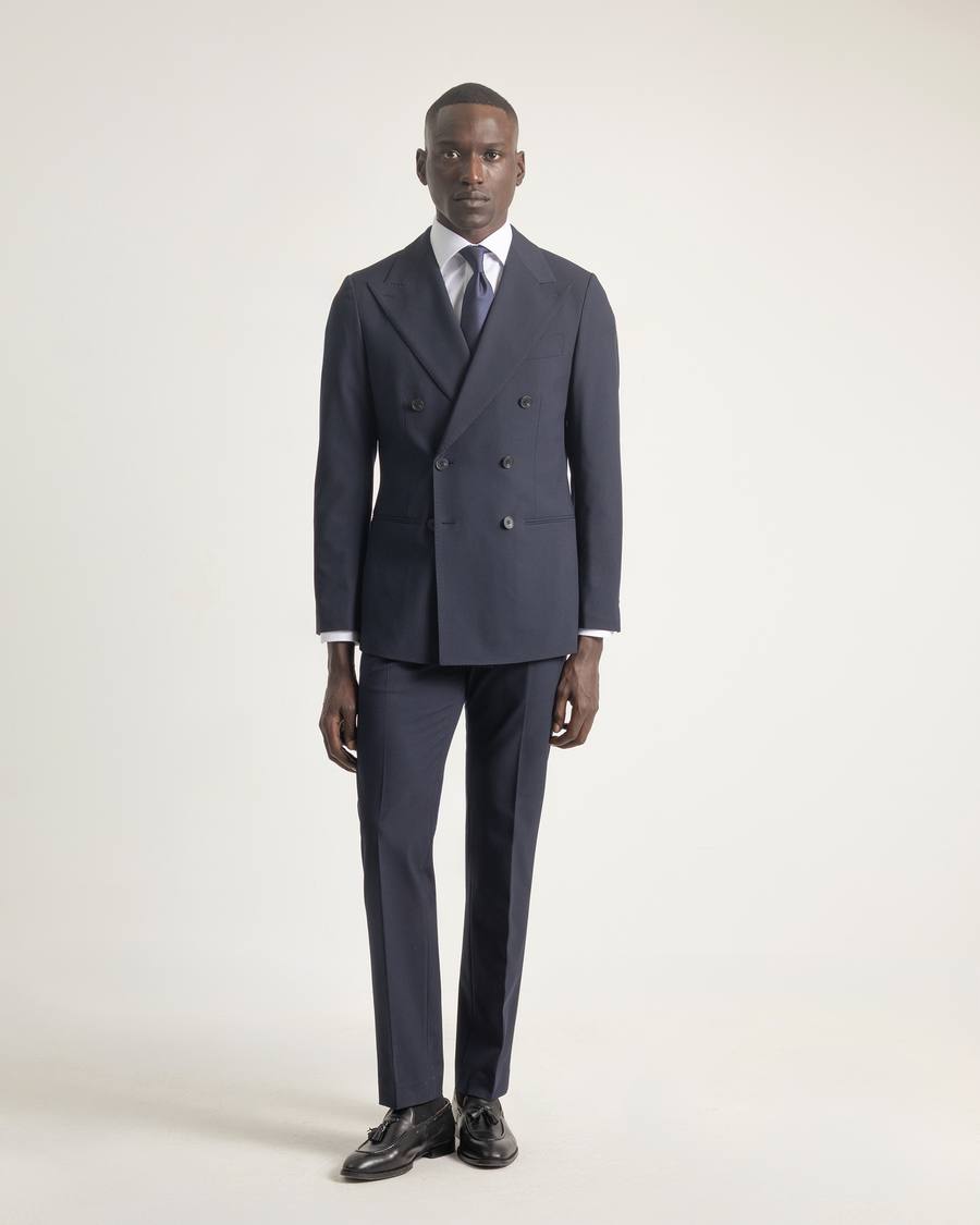 Traje cruzado 6x2 azul marino de PuroEgo de cuerpo entero, con camisa blanca y corbata, sobre fondo claro.