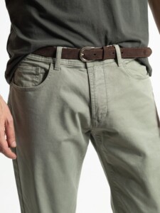 Detalle frontal del cinturón de gamuza marrón con hebilla plateada sobre pantalón verde oliva de cinco bolsillos PuroEgo