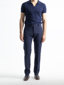 Pantalón azul marino del traje 2 piezas de frente, con raya planchada y presillas, combinado con polo azul marino y mocasines cafés.