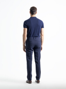Pantalón azul marino del traje 2 piezas visto de espalda, con bolsillos traseros de ojal y botón, presillas y caída recta hasta el zapato.
