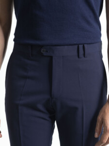 Primer plano de la cintura del pantalón azul marino del traje 2 piezas: pretina con presillas, cierre de botón y raya marcada al centro.
