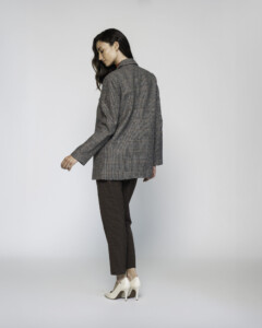 Vista lateral trasera del blazer a cuadros grises con corte recto y cuello estructurado, modelo Formentera