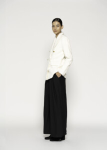 Vista lateral de blazer blanco cruzado con botones dorados, combinado con pantalón negro amplio, modelo Formentera