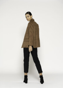 Vista lateral de blazer camel efecto ante con bolsillos de solapa, combinado con pantalón negro y botines, modelo Formentera