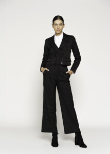 Vista completa de blazer negro con rayas finas y pantalón a juego, combinado con camisa blanca y botines negros
