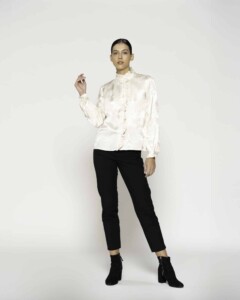 Blusa beige satinada con cuello alto y volados al frente, mangas largas, modelo Formentera.