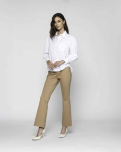 Vista completa de blusa blanca con cuello camisero y pantalones beige camel de corte acampanado, modelo Formentera