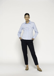 Vista frontal de blusa celeste con cuello camisero y manga larga combinada con pantalón negro, modelo Formentera