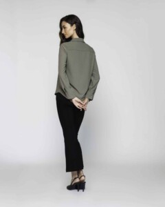 Vista de espalda de blusa verde oliva con costura central visible, cuello camisero y mangas largas con puños, modelo Formentera