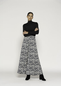 Vista frontal de body negro de cuello alto y manga larga combinado con falda larga estampada en blanco y negro
