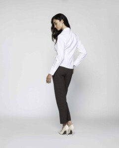 Vista de perfil lateral mostrando camisa blanca con pinzas y cuello clásico, manga larga y silueta ajustada, modelo Formentera