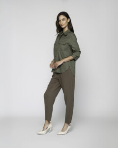 Vista lateral de camisa verde militar con bolsillos de solapa en el pecho y manga tres cuartos, combinada con pantalón modelo Formentera