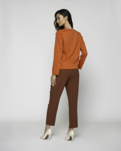 Vista posterior completa del conjunto con camiseta naranja de manga larga y pantalón marrón chocolate, modelo Formentera