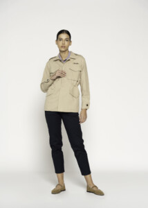 Vista frontal completa de chaqueta beige militar con cuatro bolsillos y hombreras, combinada con pantalón negro y mocasines