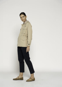 Vista de perfil lateral de chaqueta beige estilo militar con bolsillos cargo visibles, cintura ajustada y hombreras, modelo Formentera