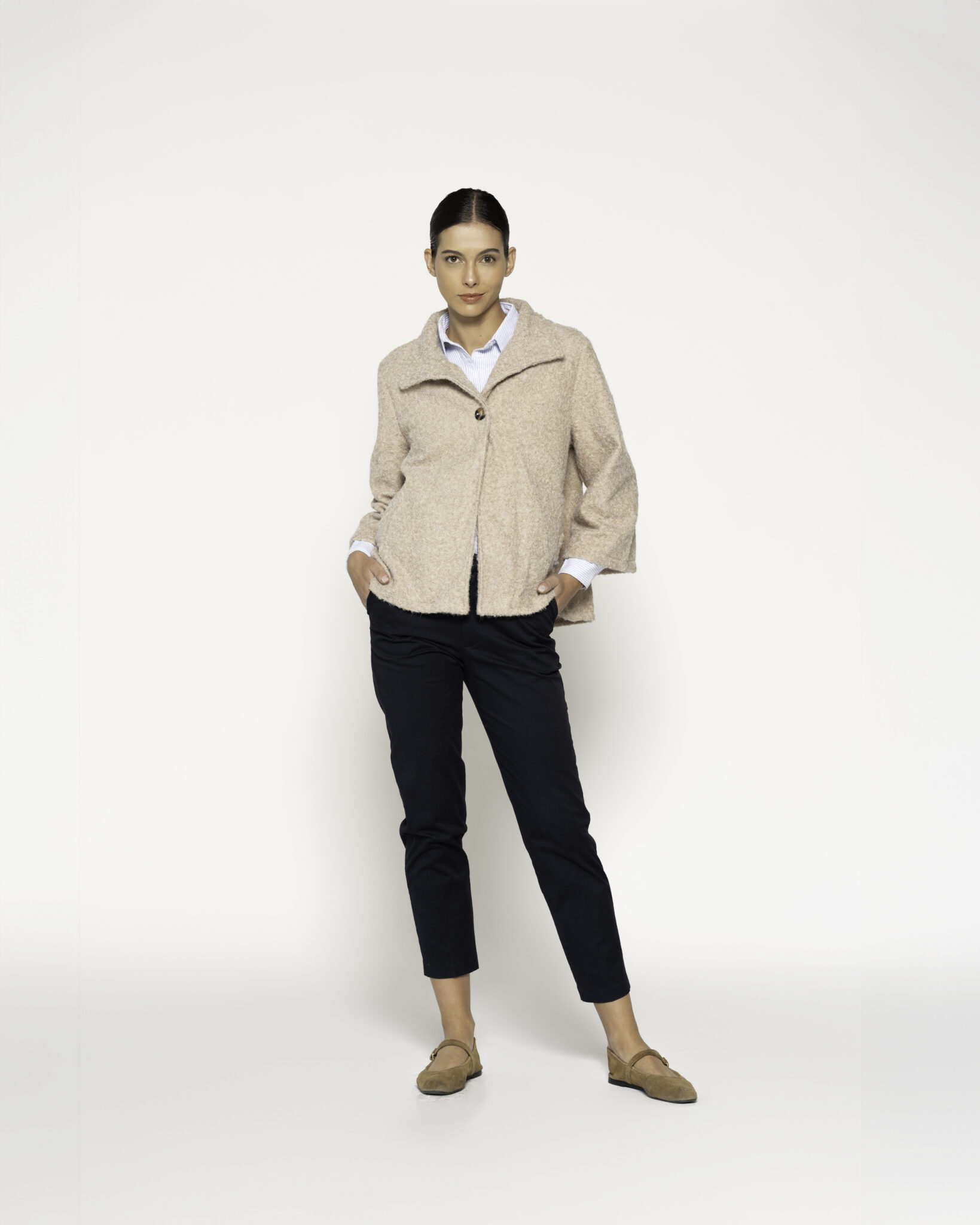 Chaqueta corta beige con cuello vuelto y un botón, vista frontal.