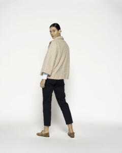 Chaqueta corta beige con cuello vuelto y un botón, vista frontal.