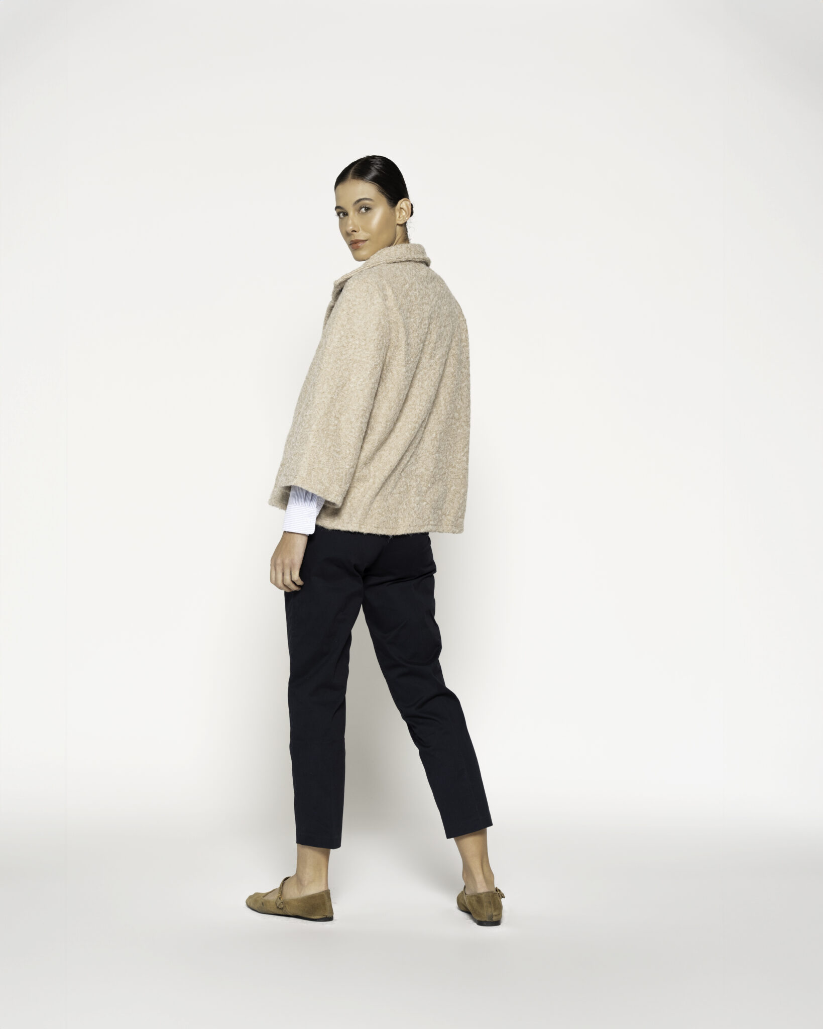 Chaqueta corta beige con cuello vuelto y un botón, vista frontal.