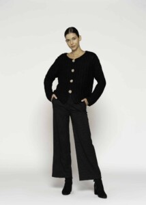 Chaqueta tejida negra con textura bouclé y cuatro botones dorados, modelo Formentera, frente.