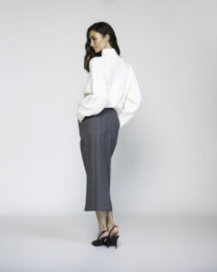 Vista de espalda de falda midi gris de corte recto con textura tejida, combinada con camisa blanca oversized, modelo Formentera