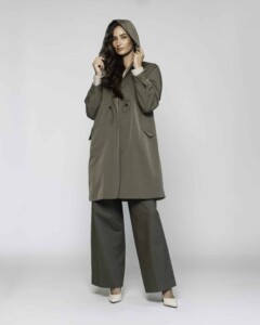 Vista completa frontal de impermeable verde militar con capucha levantada, cierre cruzado con botones y pantalón amplio a juego, modelo Formentera