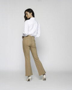 Vista de espalda del pantalón camel de corte recto con camisa blanca, se aprecia la caída recta y el largo tobillero