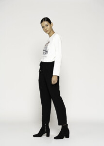Vista de perfil lateral del pantalón negro de corte recto con cordón ajustable, combinado con camiseta blanca estampada