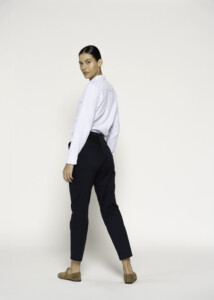 Vista de perfil trasero del pantalón negro recto con pinzas, mostrando corte entallado y largo tobillero, modelo Formentera