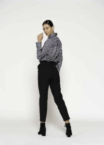 Vista de tres cuartos del pantalón negro de tiro alto combinado con camisa estampada geométrica, modelo Formentera