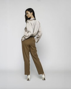 Vista trasera completa del pantalón recto camel con camisa satinada beige, mostrando caída y ajuste del modelo Formentera