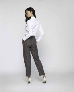 Vista de espalda de pantalón recto gris oscuro tobillero con pinzas y camisa blanca, detalle de corte y caída