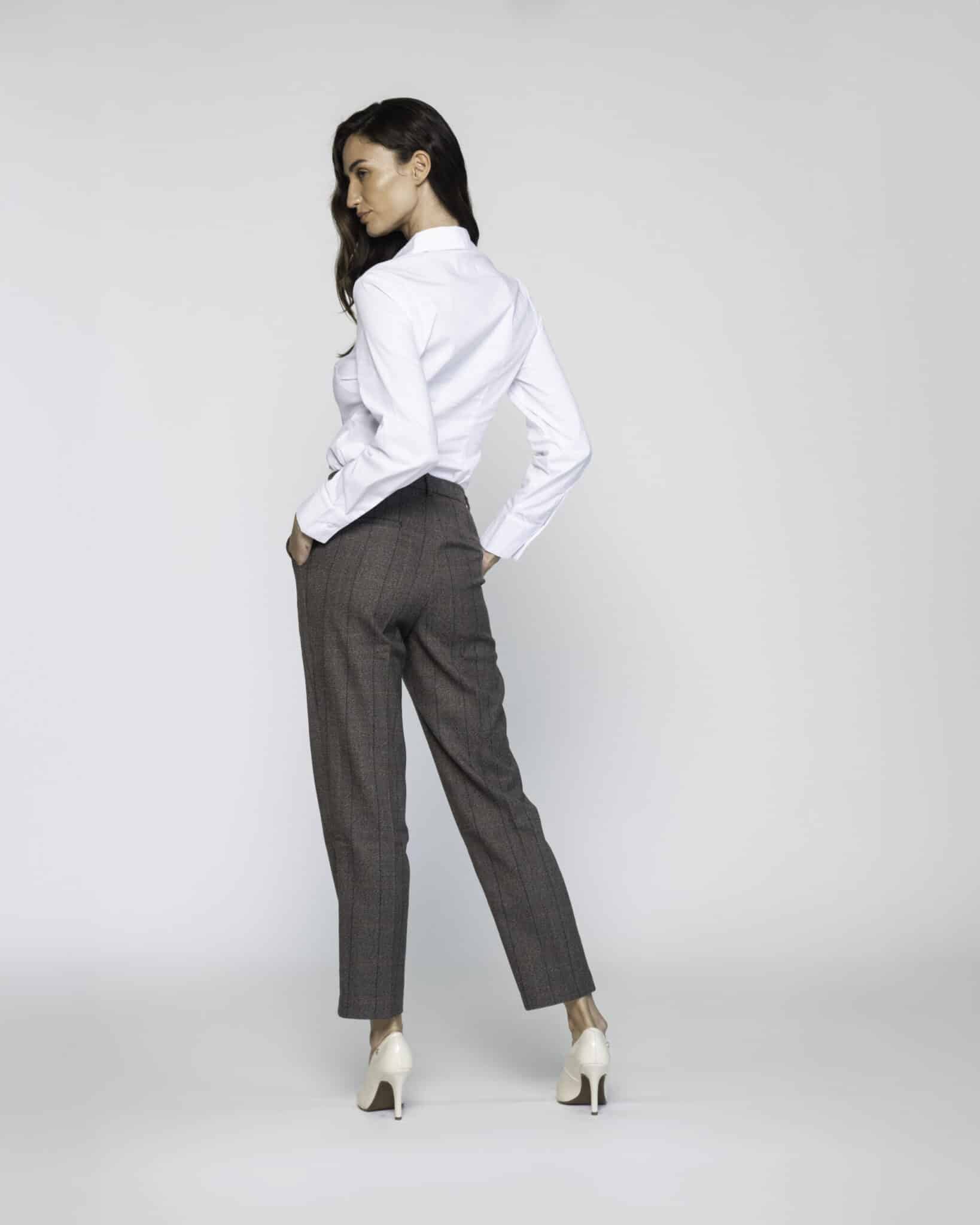 Vista de espalda de pantalón recto gris oscuro tobillero con pinzas y camisa blanca, detalle de corte y caída