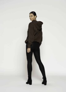 Vista de espalda de polerón café con capucha amplia sobre leggings negros y botines, modelo Formentera