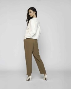 Vista trasera de polerón crudo de cuello alto con pantalón camel, se aprecian hombros caídos y corte holgado recto