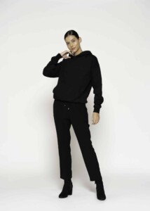 Vista completa del conjunto negro: polerón con capucha y pantalón jogger con cordón ajustable, modelo Formentera