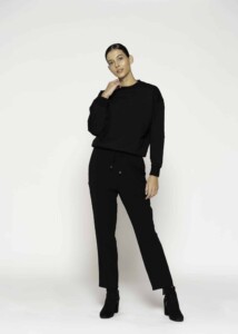 Vista completa de conjunto negro con polerón oversize de cuello redondo y pantalón recto con cordón, modelo Formentera