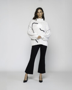 Sweater blanco de tejido grueso con cuello alto y líneas negras en el frente, modelo Formentera.