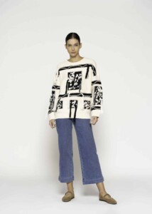 Sweater tejido crudo con diseño gráfico negro en frente y mangas, modelo Formentera, vista frontal.