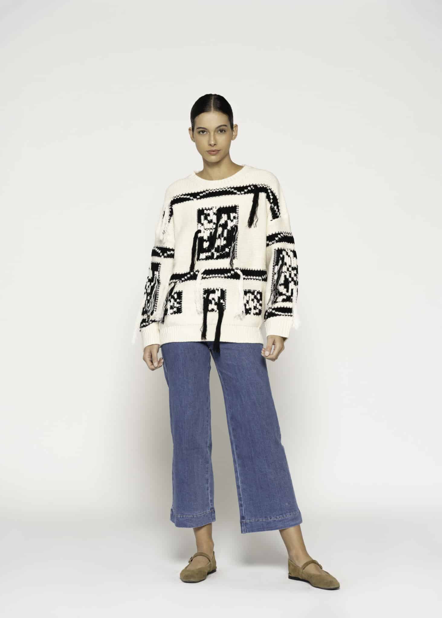 Sweater tejido crudo con diseño gráfico negro en frente y mangas, modelo Formentera, vista frontal.