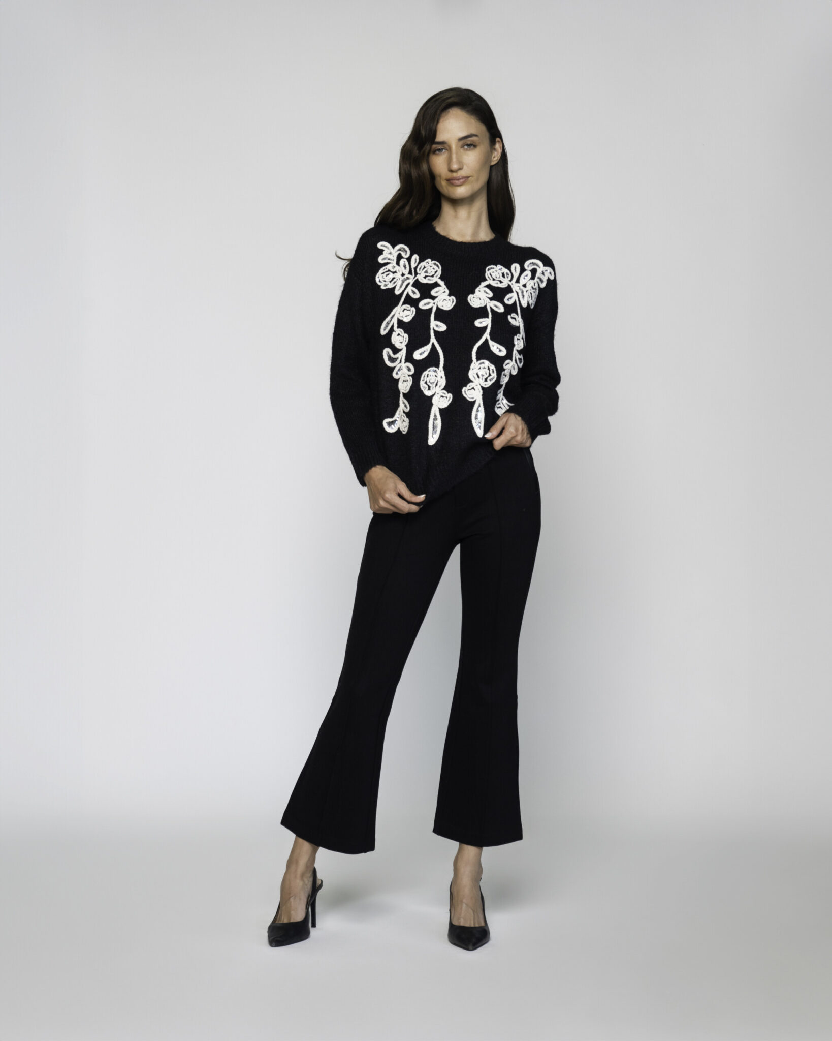 Sweater negro de punto con bordado floral blanco en el frente, manga larga, modelo Formentera.