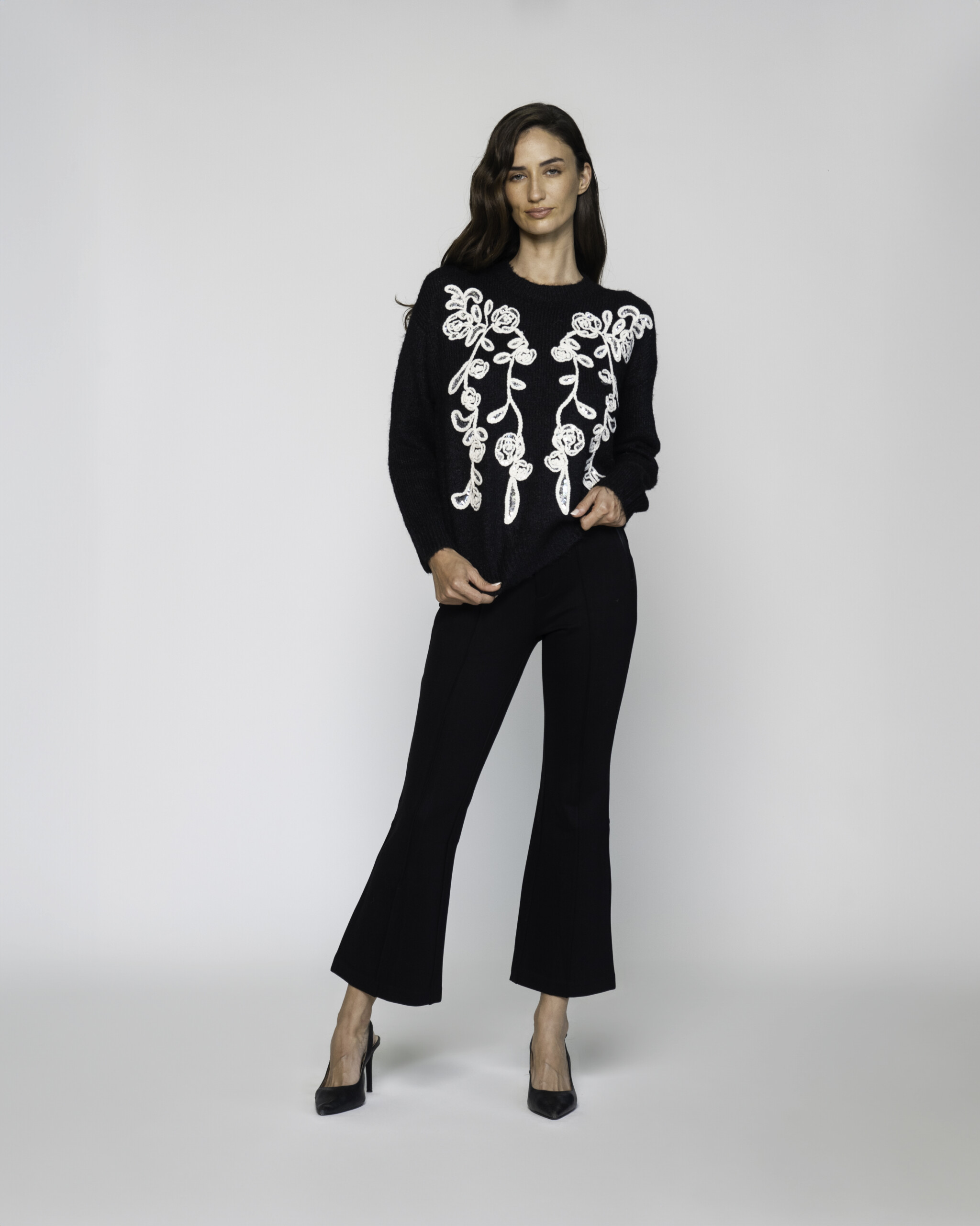 Sweater negro de punto con bordado floral blanco en el frente, manga larga, modelo Formentera.
