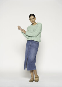 Vista completa frontal de sweater tejido verde menta con textura esponjosa combinado con falda denim midi con abertura