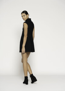 Vista de perfil lateral del vestido negro sin mangas con cuello alto, mostrando la silueta completa y el corte amplio