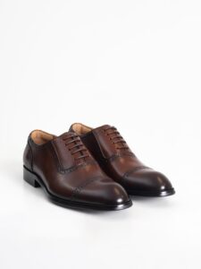 El par de zapatos oxford café con picado PuroEgo en vista de tres cuartos
