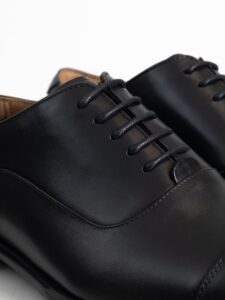 Detalle del cordonaje y de la piel del empeine del zapato oxford negro PuroEgo