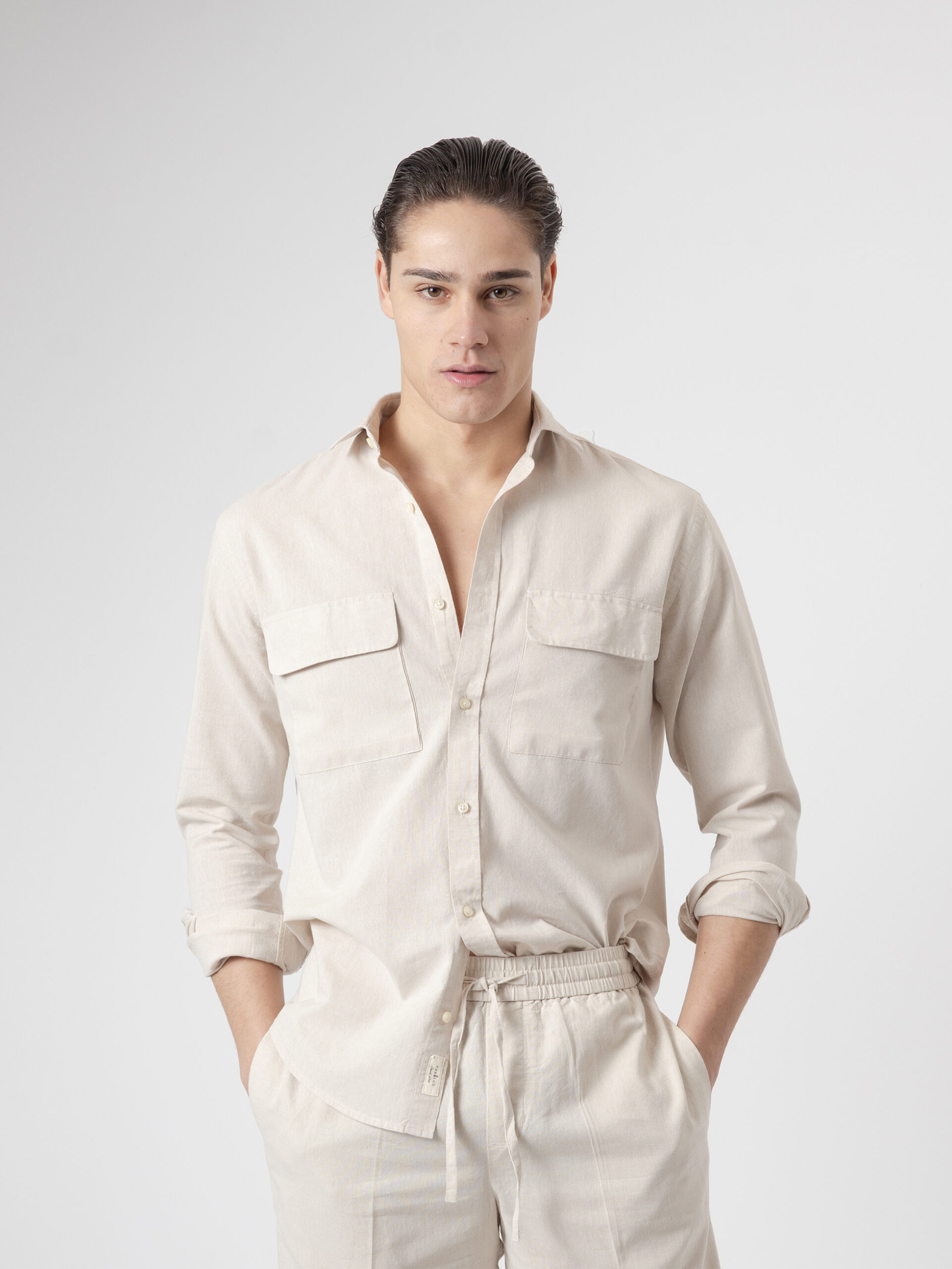 Camisa manga larga de algodón y lino en tono piedra de PuroEgo, cuello italiano y dos bolsillos con tapa, vista de frente