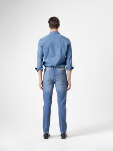Jeans slim fit azul medio de PuroEgo visto de espalda: bolsillos traseros de parche, presillas y bastilla lisa.