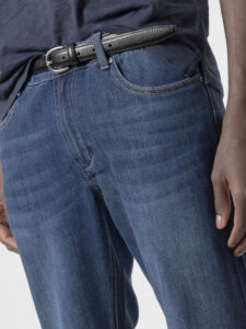 Detalle del jeans slim fit azul oscuro de PuroEgo: pretina con botón de metal, presillas, bolsillo con portamonedas y remaches.