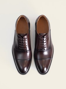 El par de zapatos oxford burdeo de PuroEgo visto desde arriba, con la puntera con costura y la plantilla de piel