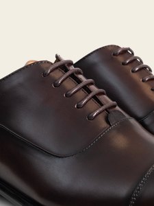 Detalle del cordonaje y de la piel del empeine del zapato oxford burdeo PuroEgo